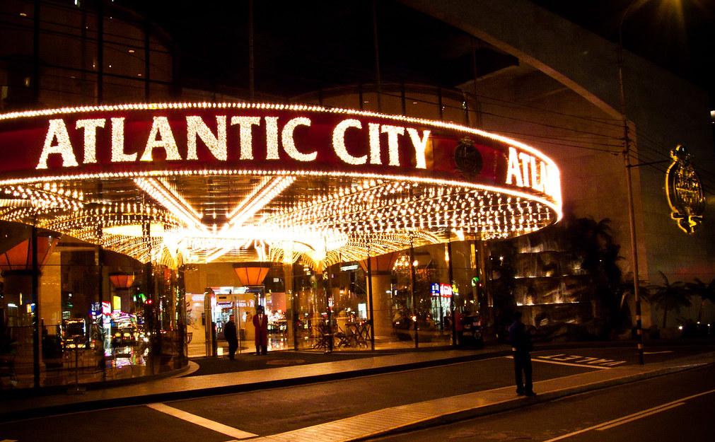 Fachada nocturna del casino Atlantic City en Lima con la marquesina encendida